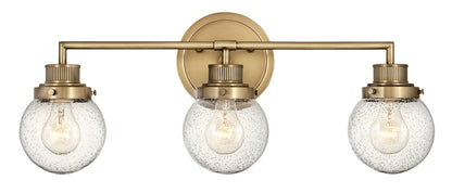Poppy Vanity by Hinkley – Lights: 3 Light (7.00"L x 24.25"W x 10.00"H) – Finish: Heritage Brass with Clear Seedy Glass and Clear Shade – Hinkley-5933HB